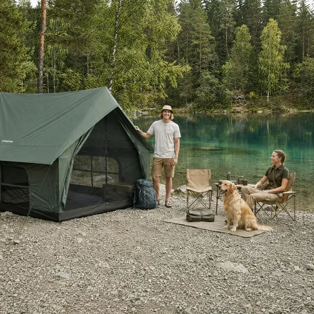 A green C5 tent beside a wooded lake, with two campers and a dog